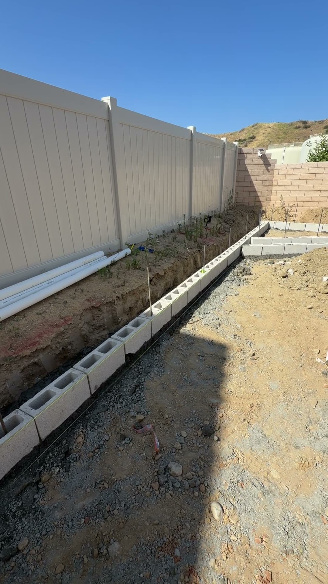 Block foundation and planter layout under construction in a new-home backyard